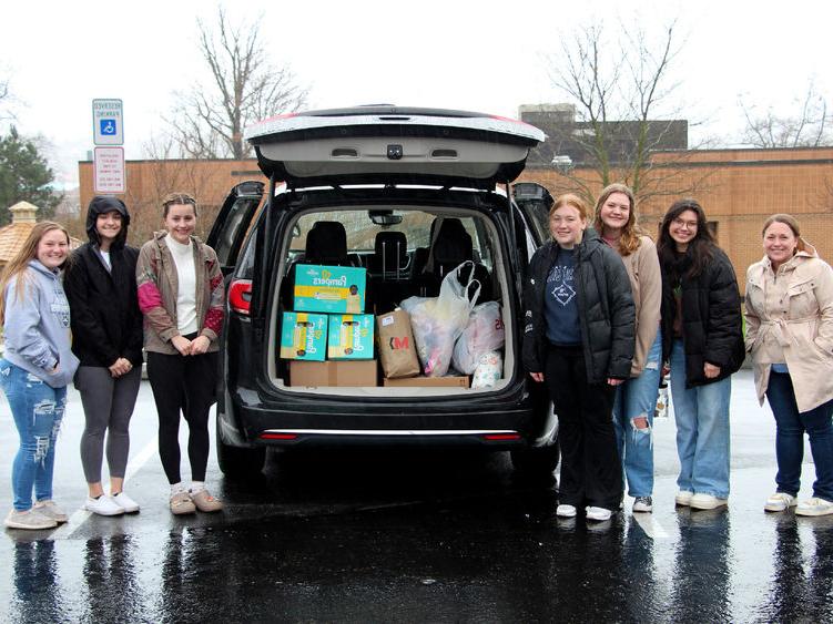 Members of the HDFS club at <a href='http://unhovd.sjunjek.com'>365英国上市</a>杜波依斯分校 stand next to the vehicle loaded with their donation items prior to their trip to the 你好邻居 location in Pittsburgh.